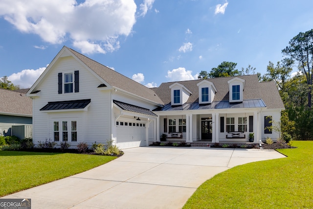 view of front of home featuring covered porch, a front lawn, and a garage