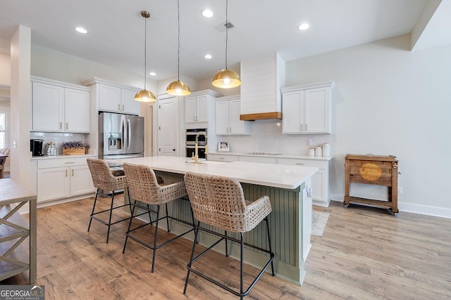 205 Park Chase, Pooler, GA 31322 - kitchen featuring stainless steel appliances, tasteful backsplash, a center island with sink, white cabinets, and a kitchen breakfast bar