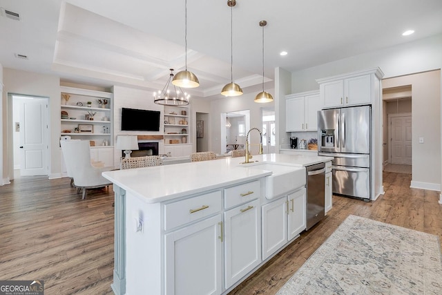 205 Park Chase, Pooler, GA 31322 - kitchen featuring appliances with stainless steel finishes, a sink, a fireplace, white cabinets, and light wood finished floors