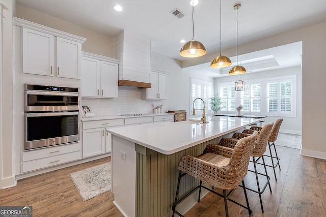 205 Park Chase, Pooler, GA 31322 - kitchen featuring stainless steel double oven, a sink, backsplash, a kitchen island with sink, and a breakfast bar area