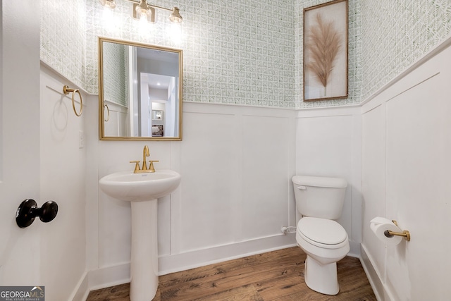 bathroom with toilet and hardwood / wood-style floors