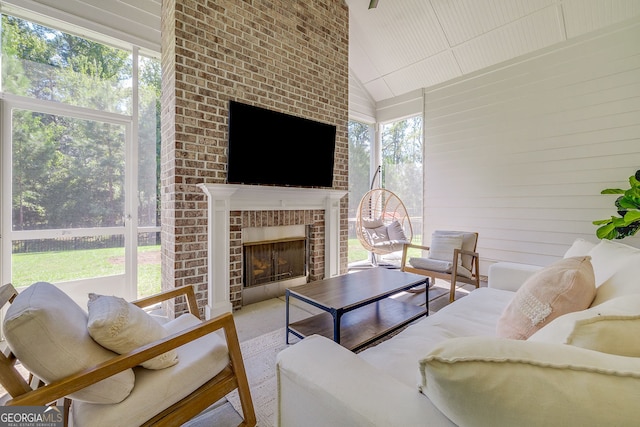 living room featuring a fireplace, wood-type flooring, lofted ceiling, and plenty of natural light