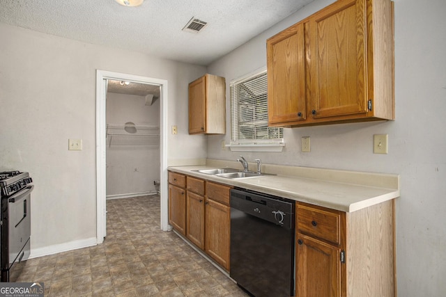 kitchen featuring dishwasher, a textured ceiling, gas stove, and sink