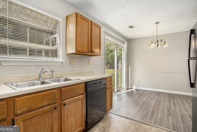 kitchen with a textured ceiling, sink, pendant lighting, an inviting chandelier, and black dishwasher