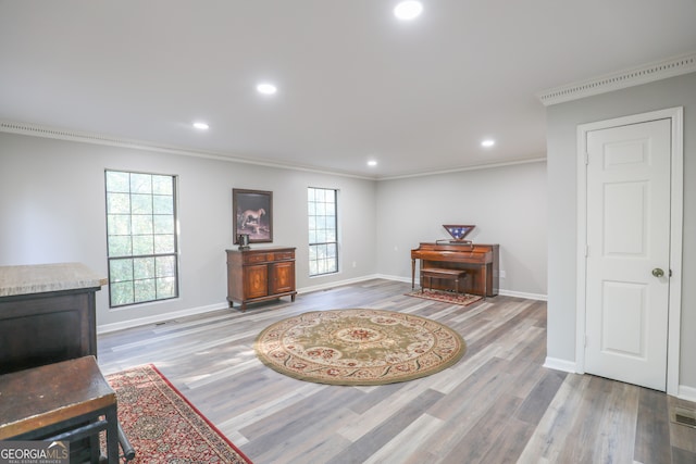 sitting room with wood-type flooring and ornamental molding