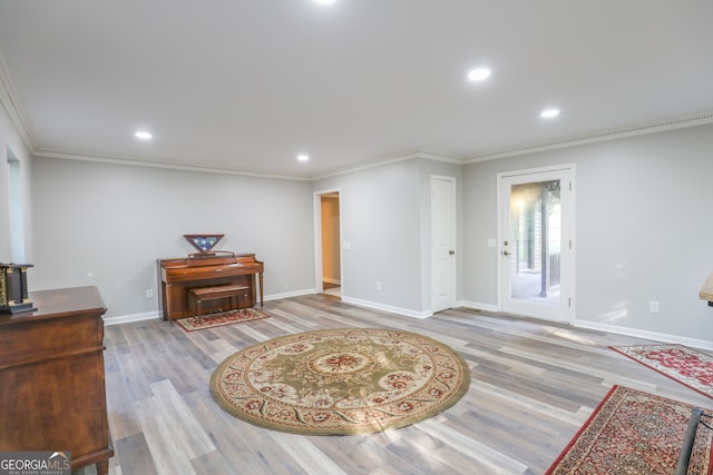 sitting room with crown molding and light hardwood / wood-style flooring