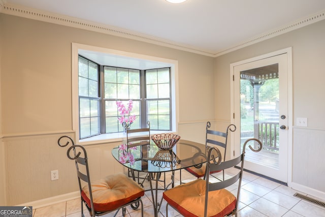 tiled dining area with plenty of natural light and crown molding