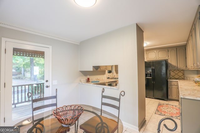 kitchen featuring black fridge with ice dispenser, light tile patterned floors, and sink