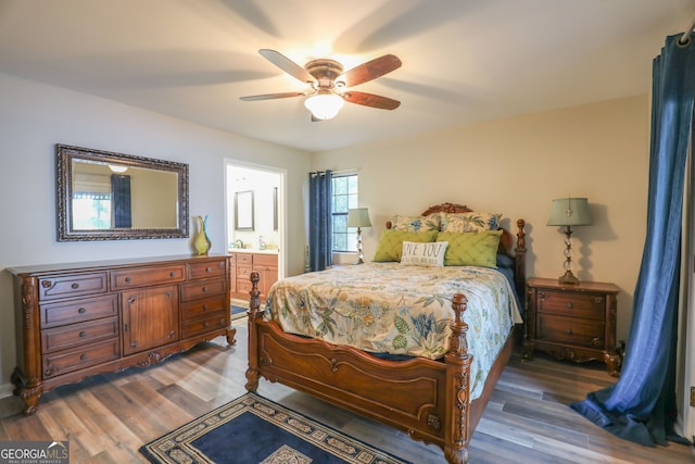 bedroom featuring ceiling fan, ensuite bath, and dark hardwood / wood-style floors