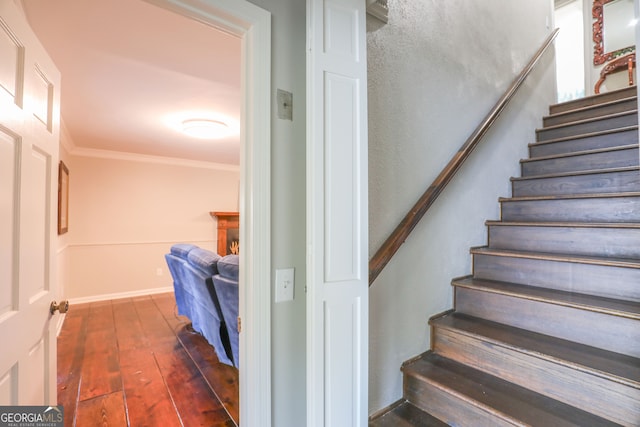 stairway with crown molding and hardwood / wood-style floors