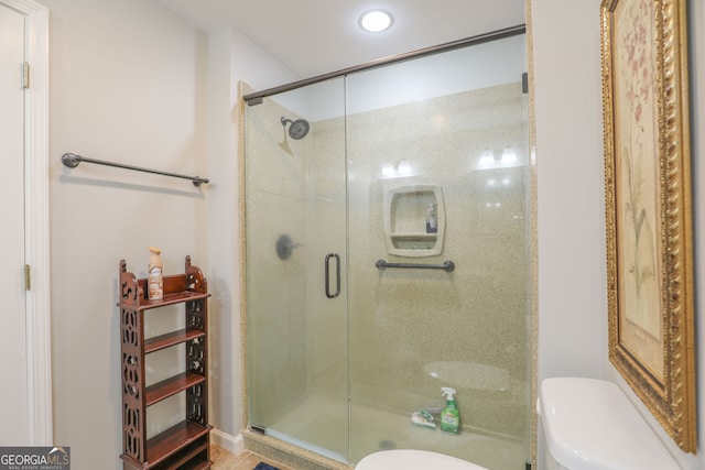 bathroom with an enclosed shower and toilet