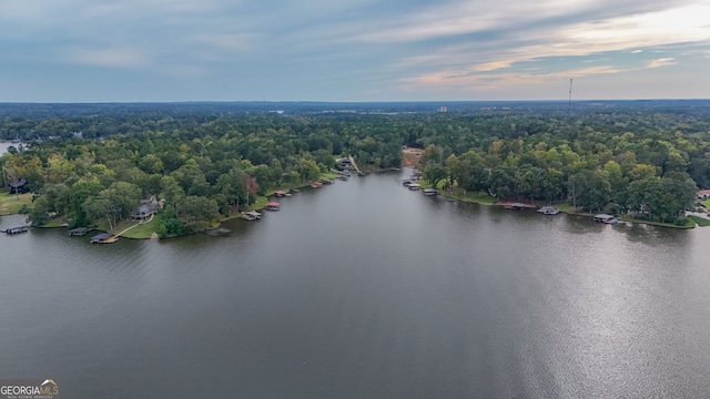 aerial view at dusk featuring a water view