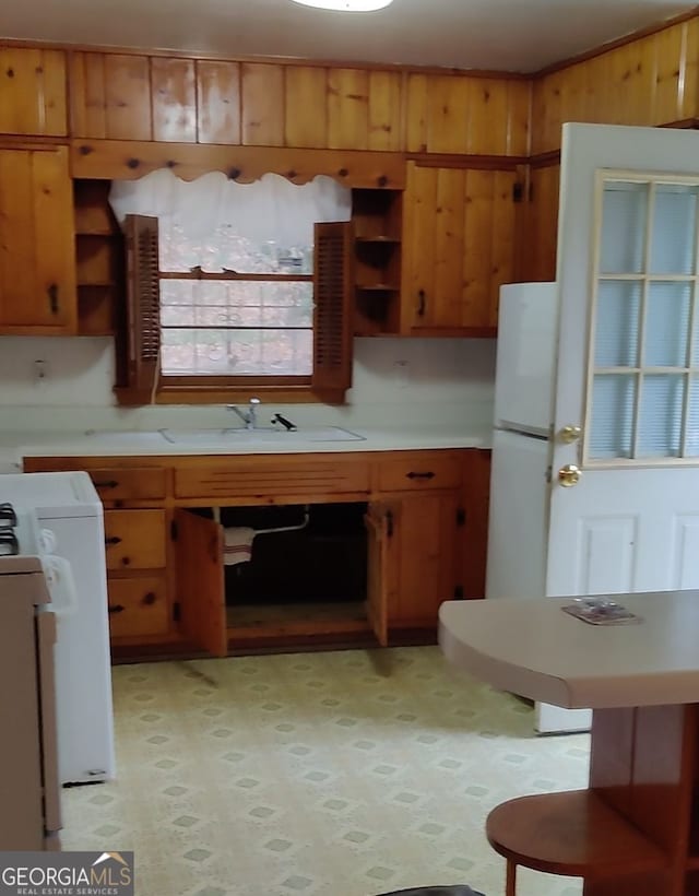 kitchen featuring wood walls and white appliances