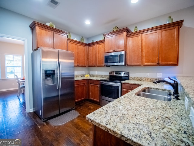 kitchen featuring light stone countertops, sink, dark hardwood / wood-style floors, and stainless steel appliances