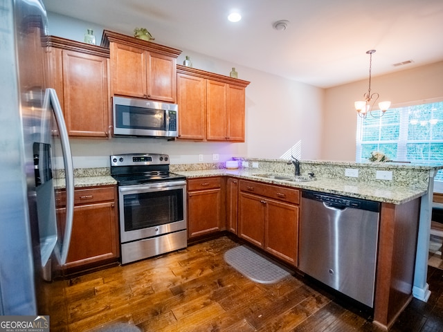 kitchen with sink, stainless steel appliances, dark hardwood / wood-style flooring, a notable chandelier, and kitchen peninsula