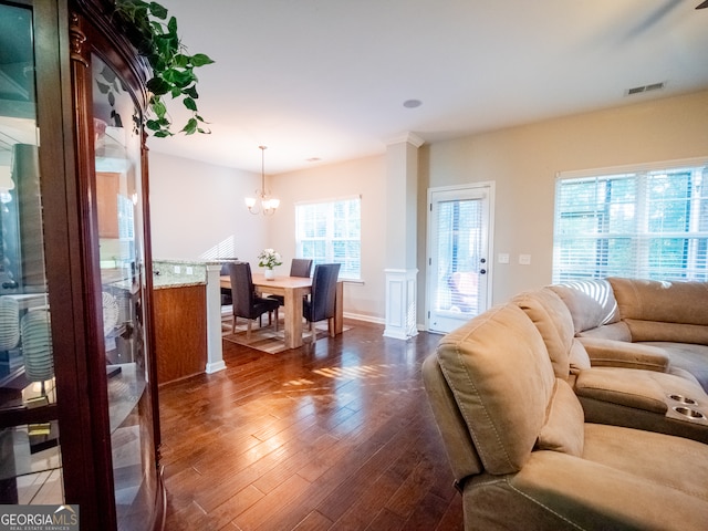 living room with a chandelier and dark wood-type flooring