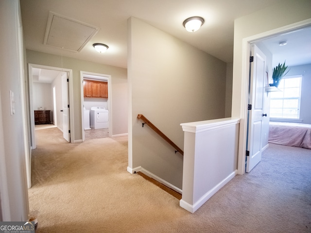 hall with light carpet and washer and dryer