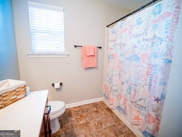 bathroom featuring vanity, toilet, and curtained shower