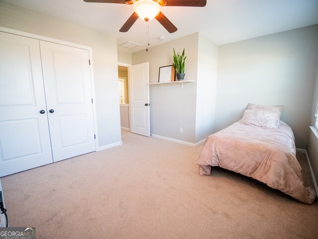 bedroom with a closet, ceiling fan, and carpet flooring