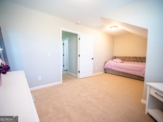 carpeted bedroom with lofted ceiling