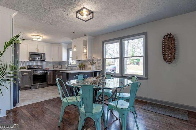 dining area with hardwood / wood-style flooring, sink, and a textured ceiling