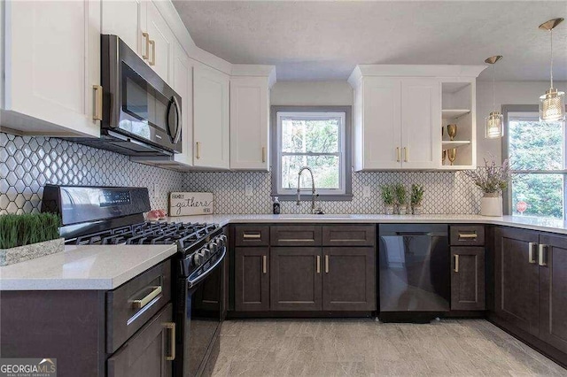 kitchen featuring sink, decorative backsplash, hanging light fixtures, black appliances, and white cabinetry