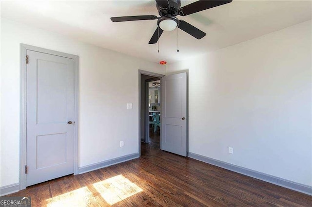 unfurnished bedroom with ceiling fan and dark hardwood / wood-style flooring