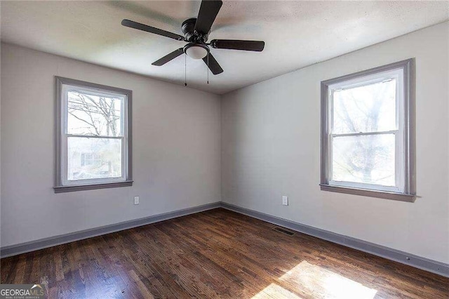 empty room featuring dark hardwood / wood-style flooring and ceiling fan