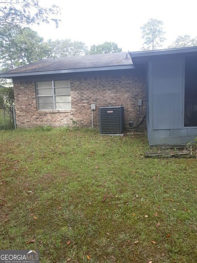 view of property exterior featuring cooling unit and a lawn