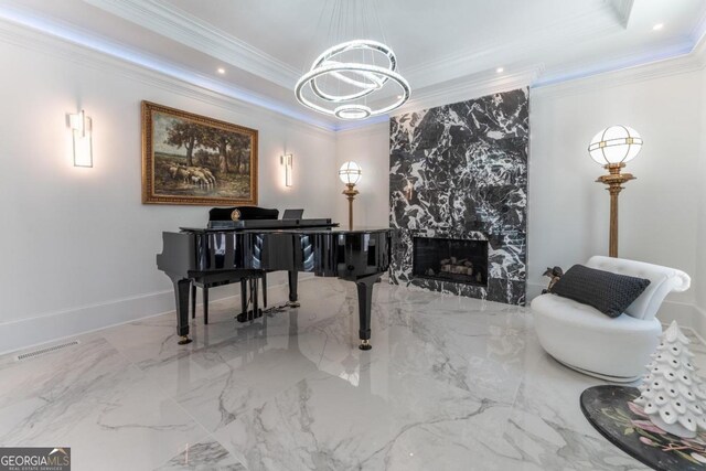 misc room with a notable chandelier, a tray ceiling, a premium fireplace, and crown molding