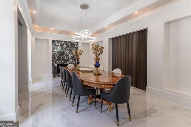 dining room with ornamental molding, a notable chandelier, and a raised ceiling