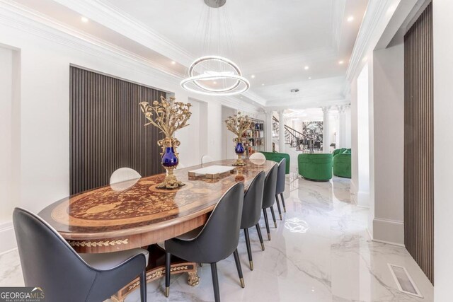 dining space featuring ornate columns, crown molding, and a notable chandelier