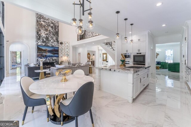 dining space featuring a towering ceiling and crown molding