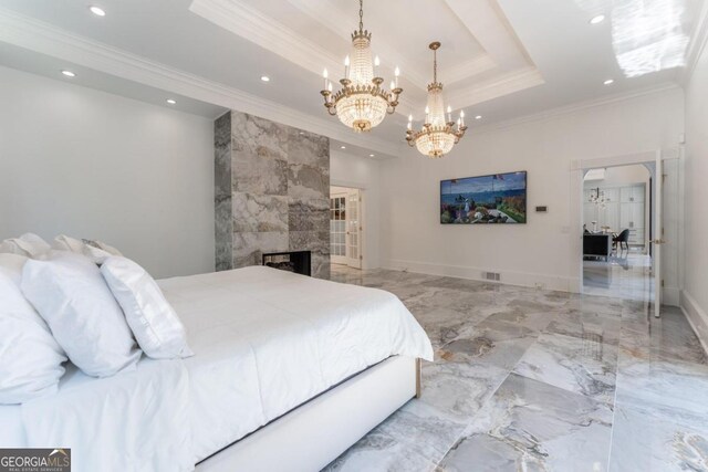 bedroom with a raised ceiling, crown molding, a notable chandelier, and a tiled fireplace