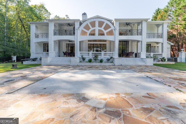 back of property featuring ceiling fan, a balcony, covered porch, and central AC unit