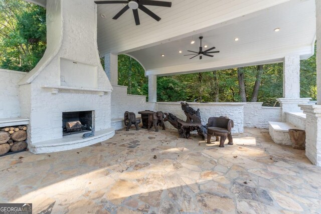 view of patio featuring ceiling fan and exterior fireplace