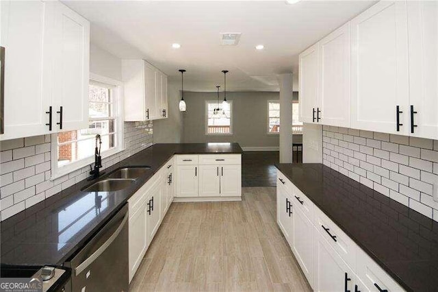 kitchen with white cabinets, sink, light hardwood / wood-style floors, and decorative backsplash