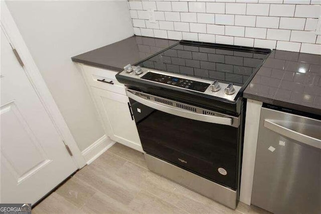 kitchen featuring stainless steel appliances, backsplash, white cabinets, and light hardwood / wood-style flooring