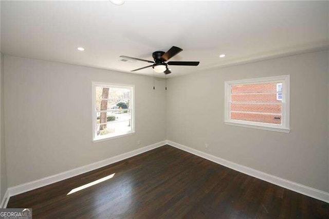 spare room featuring dark hardwood / wood-style flooring and ceiling fan