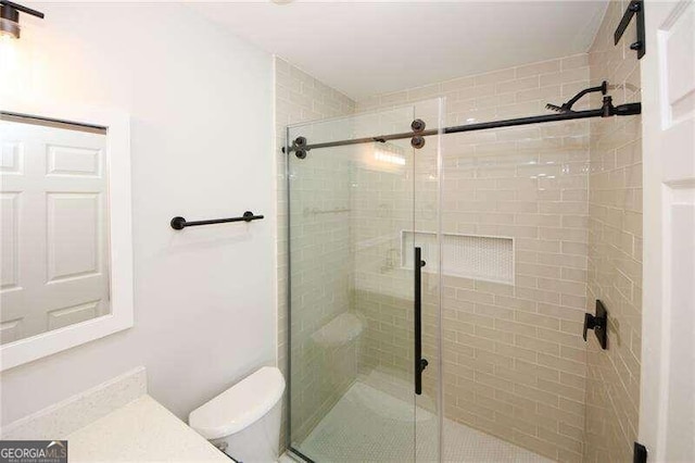 bathroom with an enclosed shower and toilet