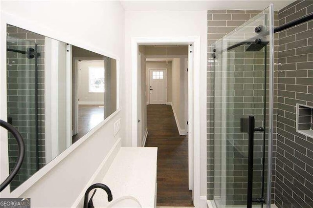 bathroom with wood-type flooring, vanity, and an enclosed shower