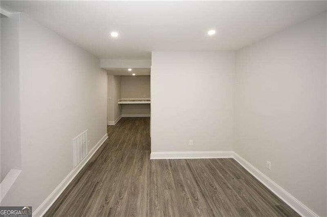 basement with dark hardwood / wood-style floors