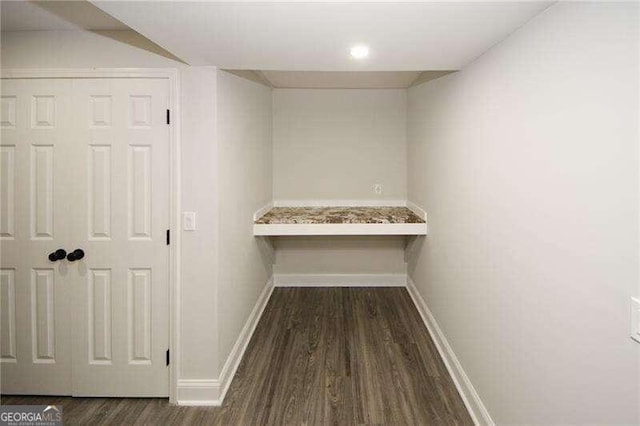 corridor with dark hardwood / wood-style flooring