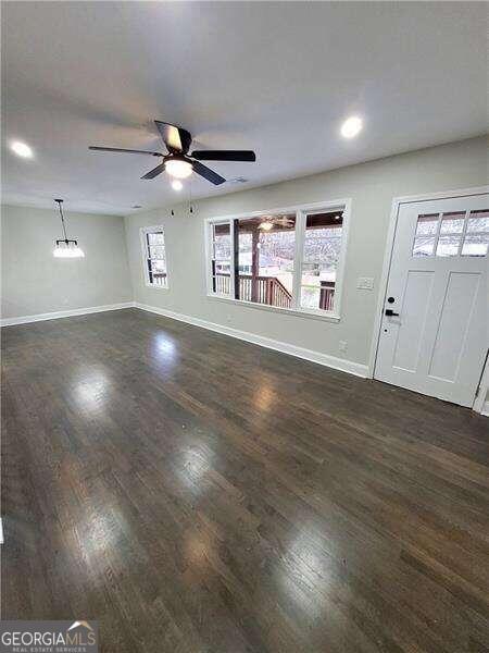 entryway featuring ceiling fan with notable chandelier and dark hardwood / wood-style flooring