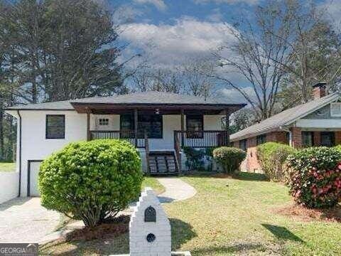 view of front of home with a porch and a front yard