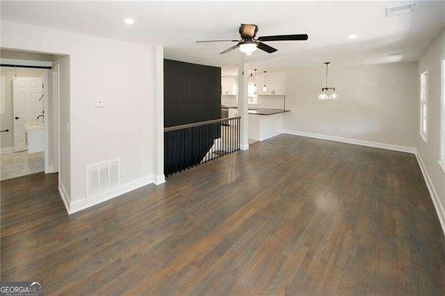 unfurnished living room with dark hardwood / wood-style floors and ceiling fan