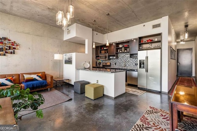 kitchen featuring appliances with stainless steel finishes, hanging light fixtures, and backsplash