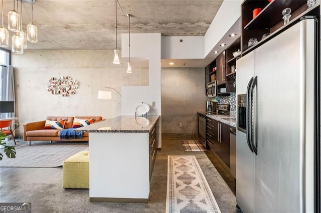 kitchen featuring stone countertops, pendant lighting, dark brown cabinetry, and stainless steel appliances