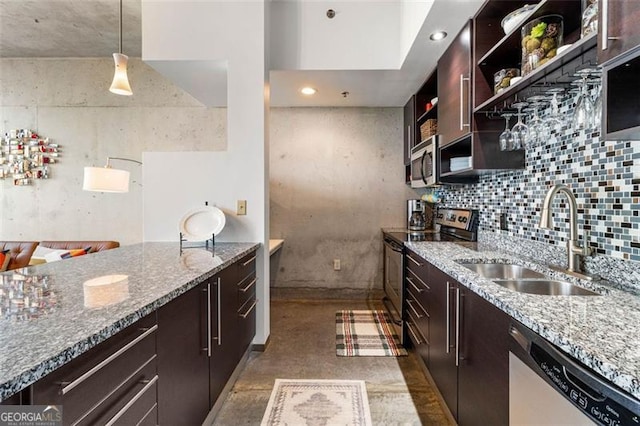 kitchen with light stone countertops, appliances with stainless steel finishes, sink, and decorative light fixtures