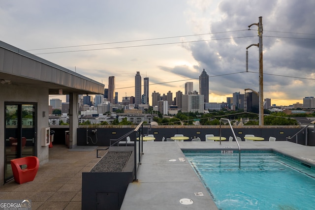 pool at dusk with a patio area